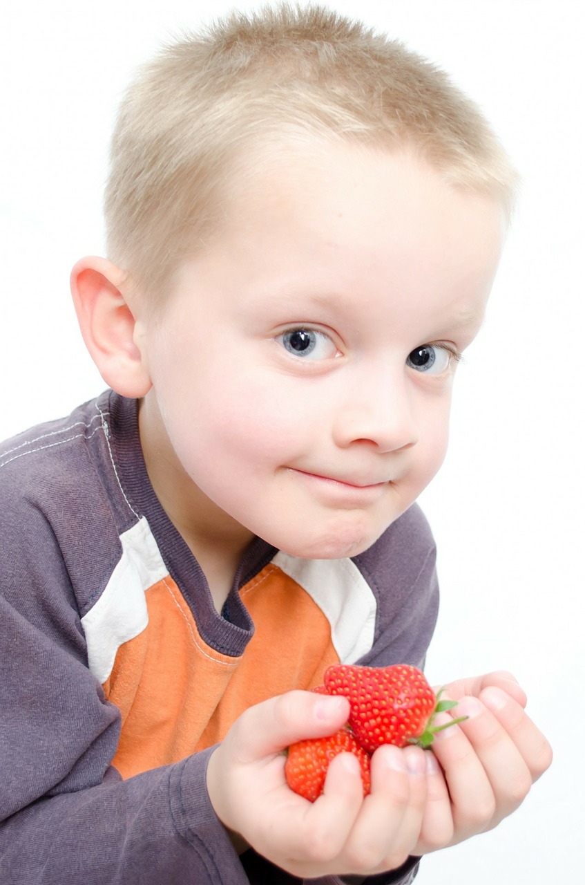 Smiling boy holding strawberries