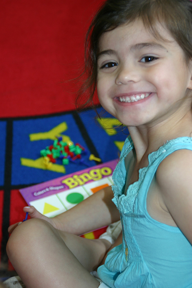 beautiful smiling brown-haired girl with Bingo board