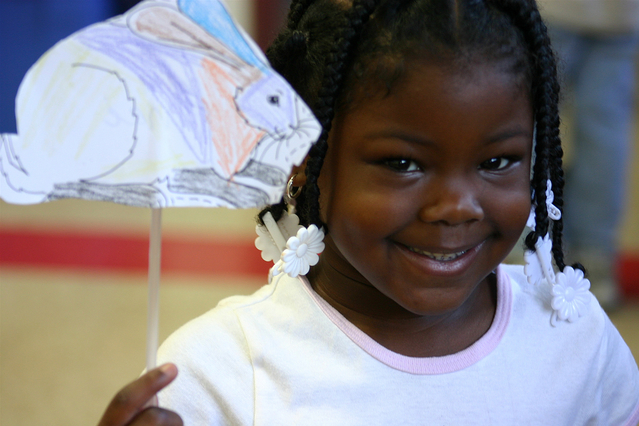 smiling girl holding a paper fish