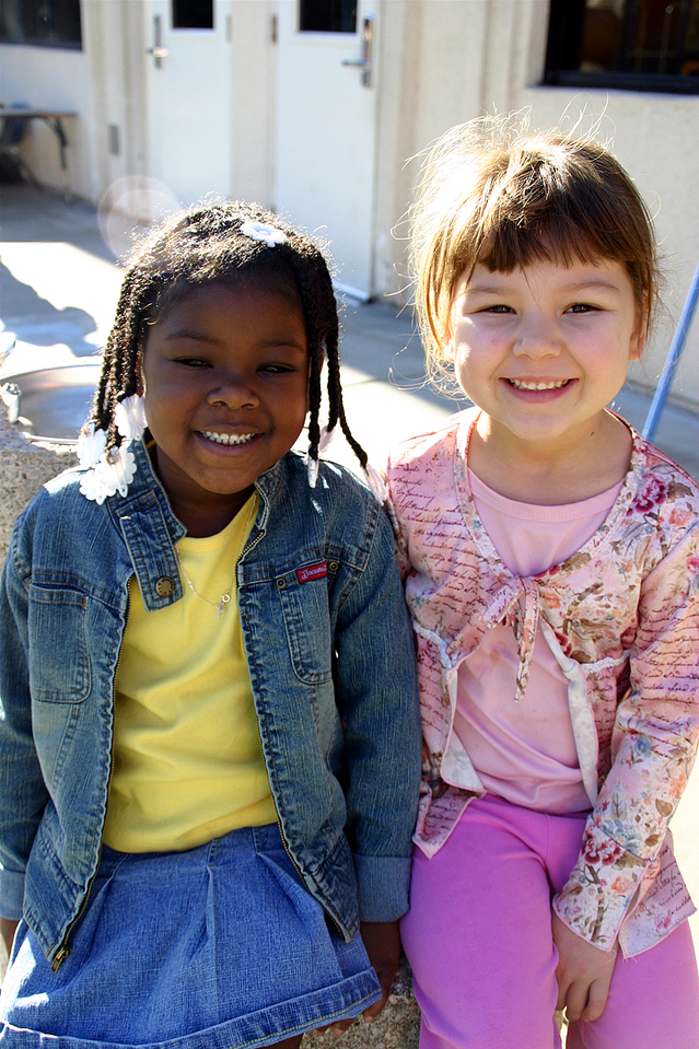 two young girls with big smiles sitting together